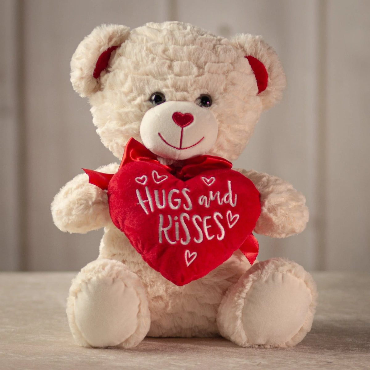 White teddy bear holding red Hugs and Kisses heart with matching bow, Valentine's gift from Clifton Park florist